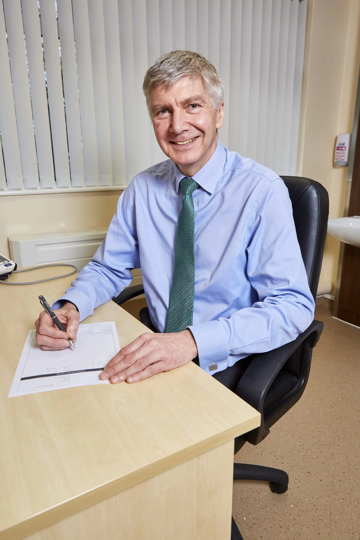 Dr Swan reviewing notes at his desk